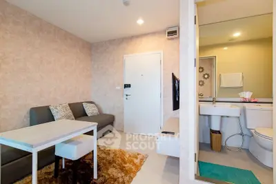 Modern living room with cozy sofa and adjacent bathroom, featuring stylish decor and warm lighting.