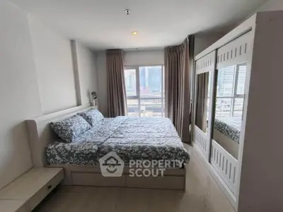 Spacious bedroom with city view and modern furnishings in high-rise apartment