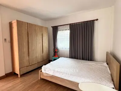 Spacious bedroom with wooden furniture and natural light