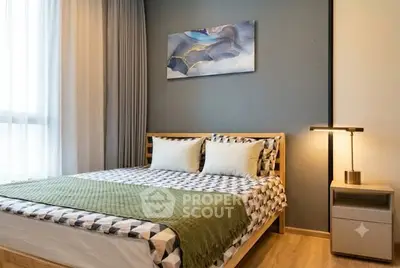 Modern bedroom with stylish decor and natural light, featuring a cozy bed and elegant bedside lamp.