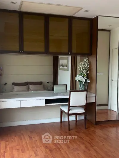 Elegant bedroom with wooden flooring and built-in wardrobe