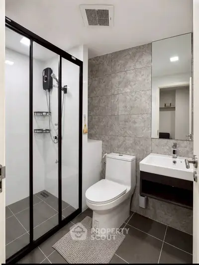 Modern bathroom with sleek shower and stylish fixtures in contemporary apartment.