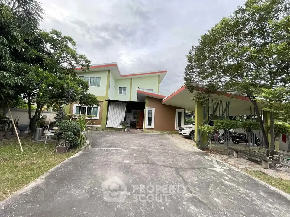 Charming two-story house with spacious driveway and lush greenery