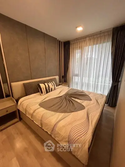 Cozy modern bedroom with stylish decor and large window for natural light.