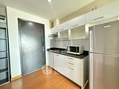 Modern kitchen with sleek cabinets and stainless steel appliances in a stylish apartment.