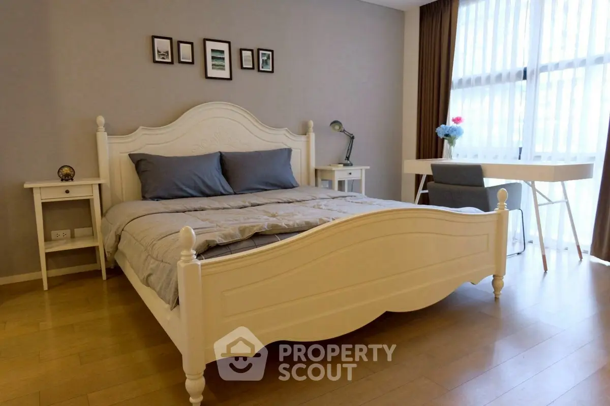 Elegant bedroom with stylish decor and natural light, featuring a cozy bed and modern desk.