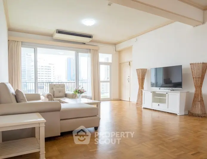 Spacious living room with modern furniture and large windows offering city views.