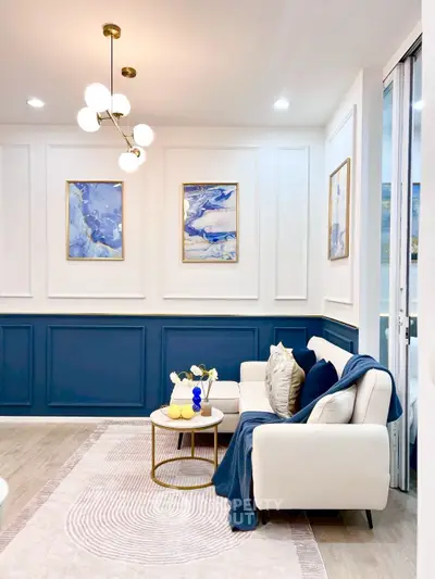 Elegant living room with modern decor, blue accents, and stylish lighting