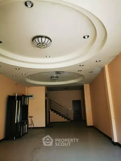 Spacious interior with modern ceiling design and staircase, ideal for customization.