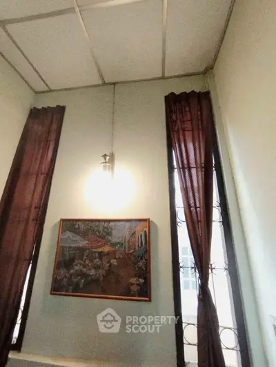 Charming interior with high ceilings and elegant wall art, perfect for a cozy living space.