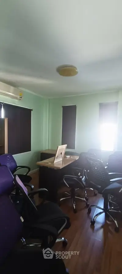 Spacious office room with modern chairs and wooden flooring, ideal for productive meetings.