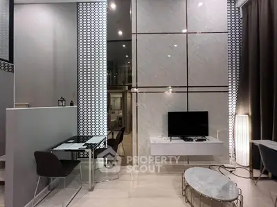 Modern living room with high ceiling and stylish decor in a contemporary apartment.