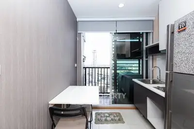 Modern kitchen with balcony view, sleek appliances, and dining area in a stylish apartment.