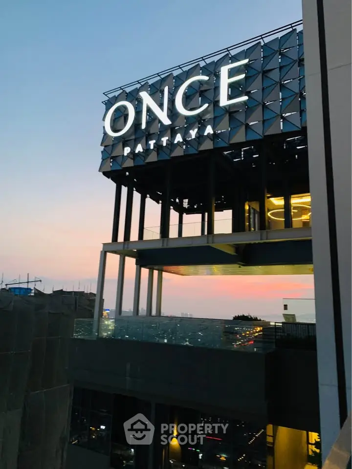 Stunning view of modern building exterior at sunset with illuminated signage.