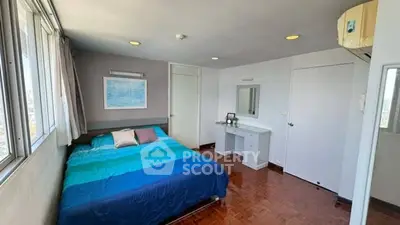 Bright bedroom with large windows and modern decor, featuring a cozy bed and stylish furnishings.