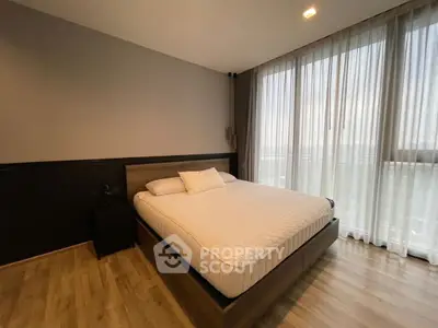 Spacious bedroom with large window and modern decor
