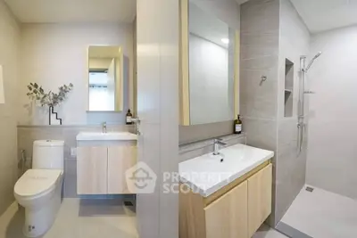Modern bathroom with sleek fixtures and minimalist design, featuring a spacious shower and elegant vanity.