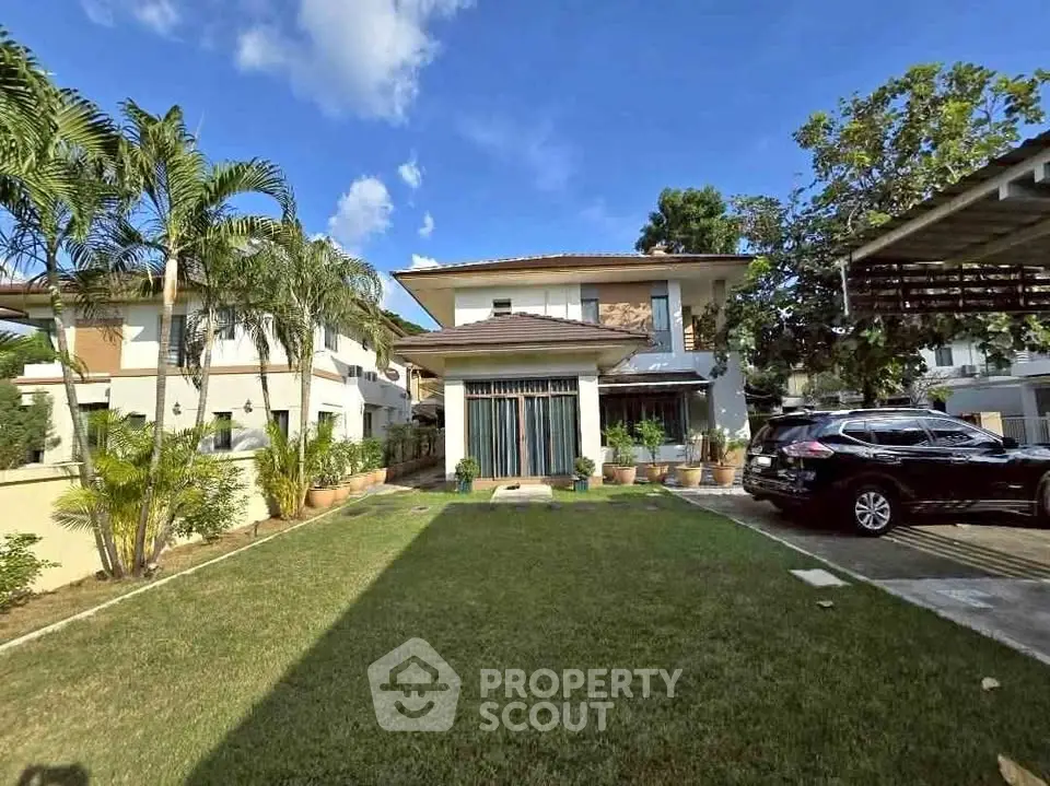 Charming two-story house with lush garden and driveway in a serene neighborhood.