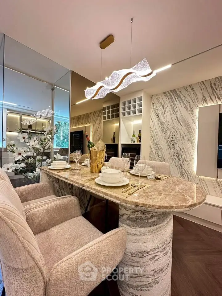 Luxurious dining area with elegant marble table and modern lighting in stylish apartment.