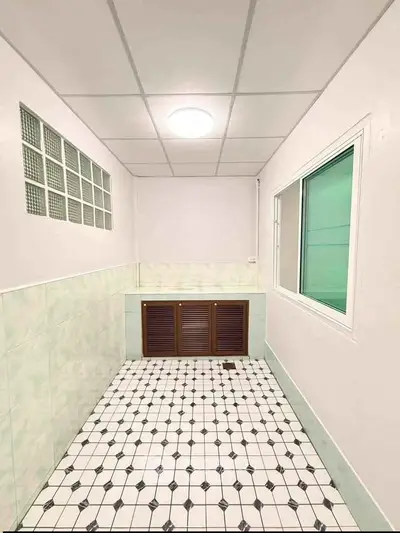 Spacious utility room with tiled floor and built-in storage, ideal for laundry or storage needs.