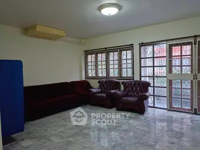 Spacious living room with marble flooring and elegant leather seating.