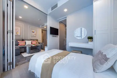 Modern bedroom with stylish decor and open layout leading to cozy living area.