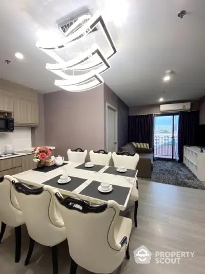 Elegant dining area with modern chandelier and cozy seating in stylish apartment