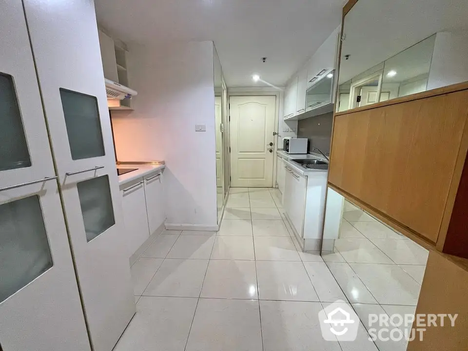 Spacious kitchen with modern white cabinetry and sleek tile flooring