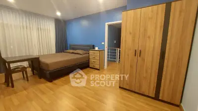 Spacious bedroom with modern furniture and wooden flooring