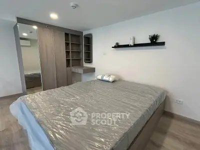 Modern bedroom with sleek design, featuring a large bed, built-in wardrobe, and minimalist decor.