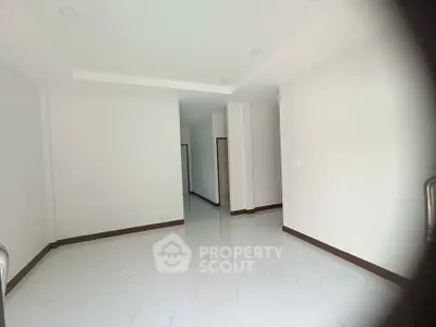 Spacious empty room with white walls and glossy floor, perfect for customization.