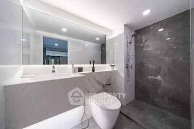 Luxurious modern bathroom with sleek marble design and spacious shower area.