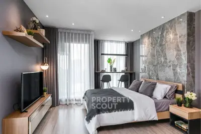 Modern bedroom with stylish decor, large windows, and elegant furnishings in a contemporary apartment.