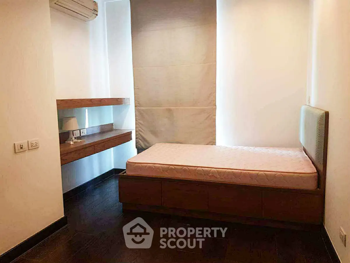 Cozy minimalist bedroom with single bed and wooden flooring