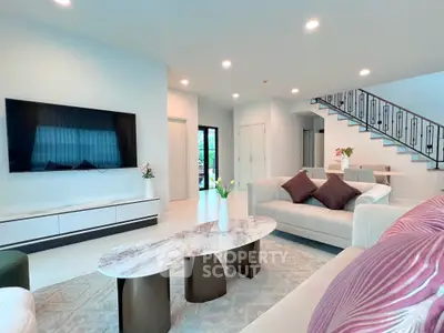 Spacious modern living room with elegant decor and large TV, perfect for relaxation and entertainment.