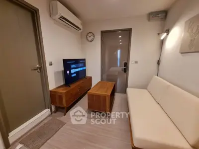 Cozy living room with modern furniture and wall-mounted TV, perfect for relaxation.