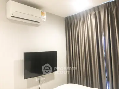 Modern bedroom with wall-mounted TV and air conditioning unit