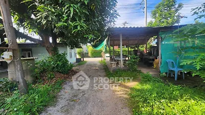 Charming rural property with lush greenery and outdoor seating area.