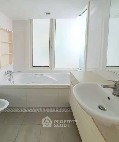 Spacious bathroom with modern fixtures and large bathtub, perfect for relaxation.