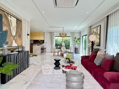 Luxurious open-plan living room with elegant decor and modern kitchen, perfect for entertaining.