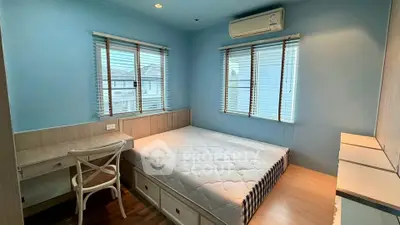 Cozy bedroom with natural light, featuring a comfortable bed, wooden desk, and air conditioning.