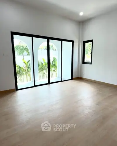 Spacious room with large windows and garden view, perfect for natural light lovers.