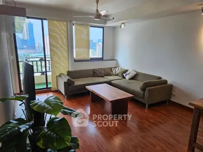 Spacious living room with city view, modern sofa, and wooden flooring.