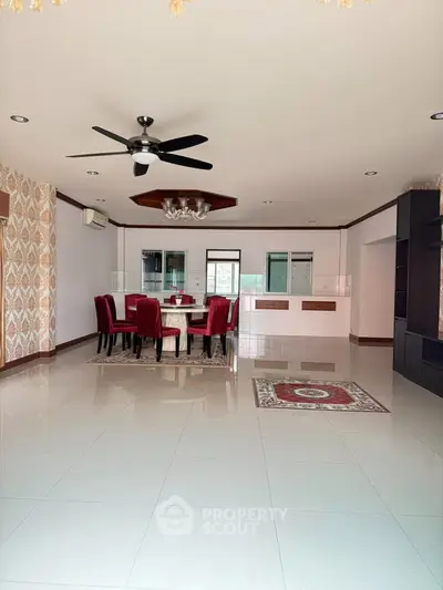 Spacious open-plan living and dining area with elegant decor and ceiling fan.