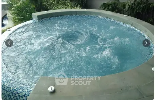 Luxurious outdoor jacuzzi with lush greenery, perfect for relaxation and leisure in a serene setting.