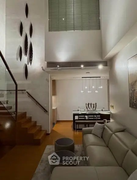 Luxurious modern living room with high ceiling and elegant staircase