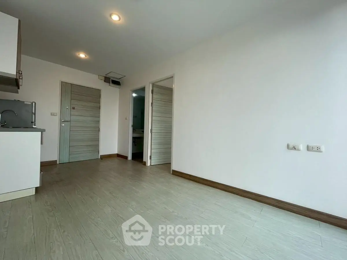 Spacious modern apartment interior with sleek wooden flooring and minimalist design.