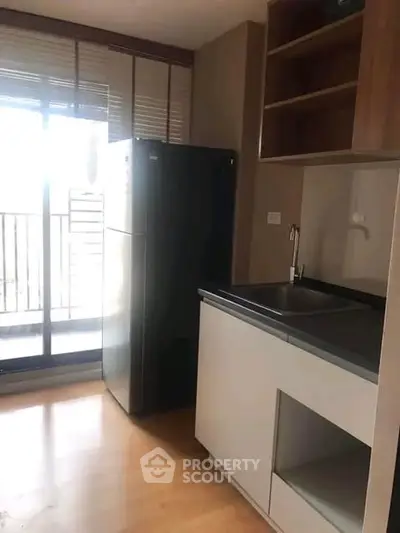 Modern kitchen with sleek appliances and balcony access in a stylish apartment.