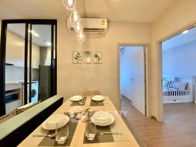 Modern dining area with elegant table setting and view into cozy bedroom
