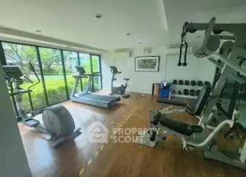 Modern gym with state-of-the-art equipment and garden view, perfect for fitness enthusiasts.